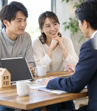 テーブルを囲んで家づくりの相談をするご夫婦と担当者